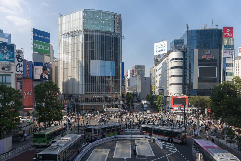 Pedestrians walk over Shibuya crossing during a sunny day, when temperatures have risen over 36 degrees celsius in Tokyo.