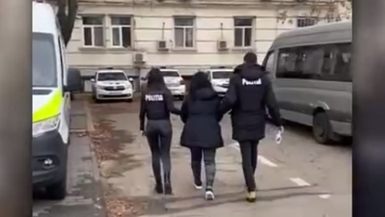 femeie retinuta, escortata de doi politisti