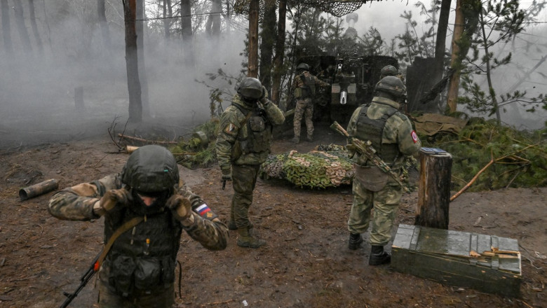 Russian servicemen fire a 2A65 Msta-B 152 mm towed howitzer towards Ukrainian positions