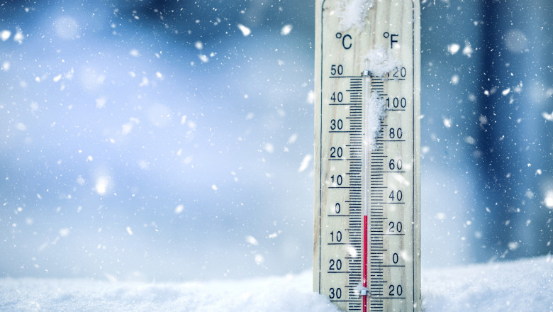 Thermometer on snow shows low temperatures - zero. Low temperatures in degrees Celsius and fahrenheit. Cold winter weather - zero celsius thirty two farenheit