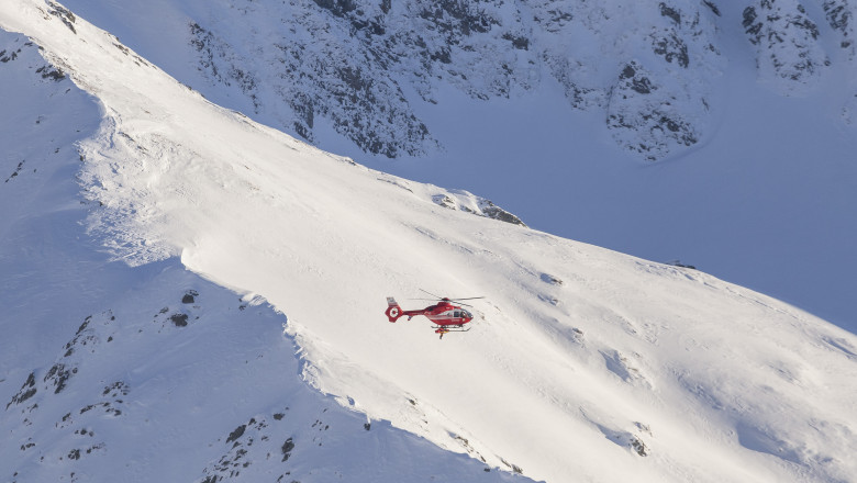 munții făgăraș cu zăpadă și un elicopter cu salvatori
