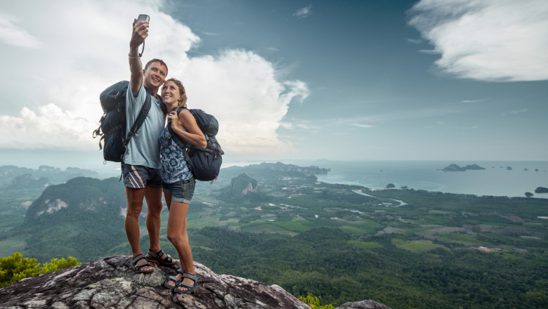 turisti care isi fac un selfie pe marginea unei prapastii