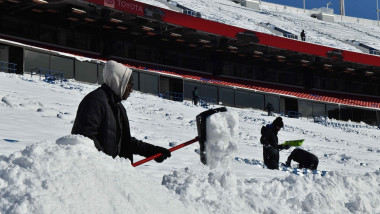 Om care scoate zăpada cu lopata pe un stadion