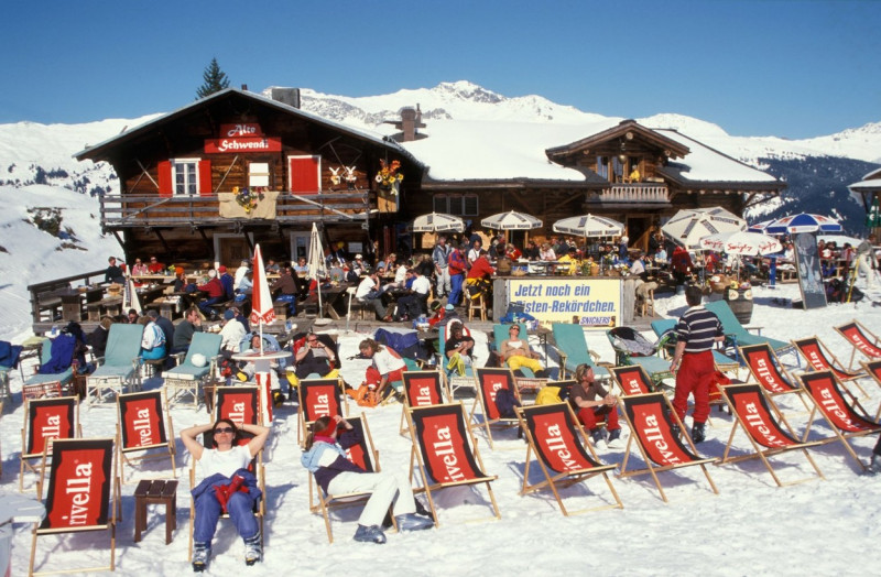 skiers and snowboarders at lunch and sitting in the sun at the Alte Schwendi mountain restaurant Davos Switzerland