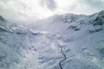 Snow covered peaks of mountains during winter on a sunny day with clouds in Fluela Pass, Davos, Switzerland.