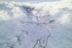 Snow covered peaks of mountains during winter on a sunny day with clouds in Fluela Pass, Davos, Switzerland.