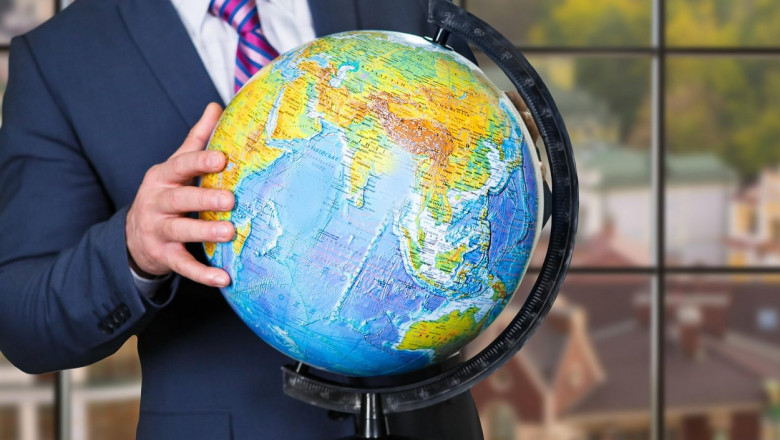 Businessman touching globe with hand.