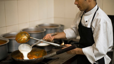 A chef prepares a dish of butter chicken at Moti Mahal Restaurant in Old Delhi, India