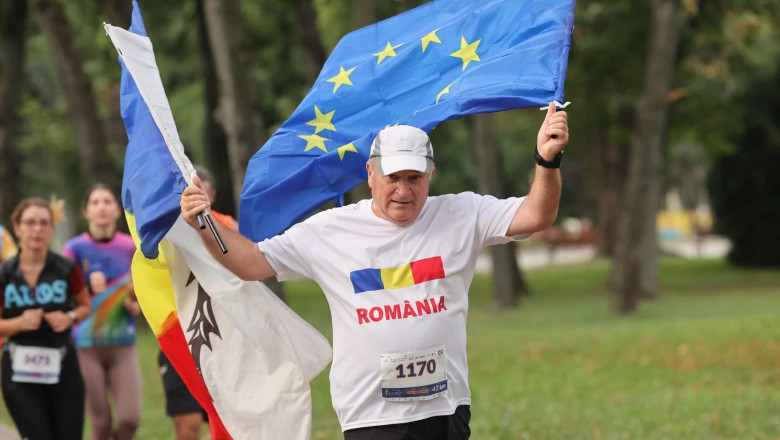 ilie rosi maratonist alearga cu steaguri Ro si UE in mana, sapca pe cap