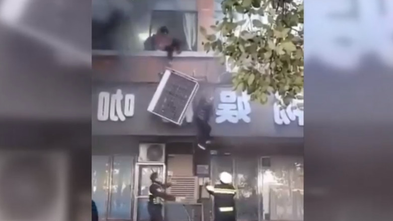 Oamenii ies pe fereastră pentru a se salva din incendiu.