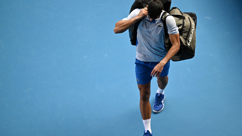Novak Djokovic părăsește terenul de tenis de la Australian Open după ce a fost înfrânt în semifinală.