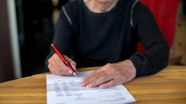 o femeie in varsta semneaza un document
