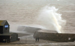 Dog walkers get a soaking on the Cobb Wall in Lyme Regis, Dorset as Storm Isha approaches.