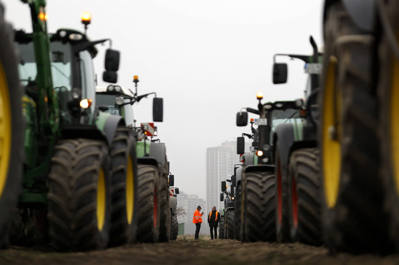 Teilnehmer der Bauernproteste fahren in Köln mit ihren Traktoren im Korso und präsentieren dabei Schilder mit Aufschrift
