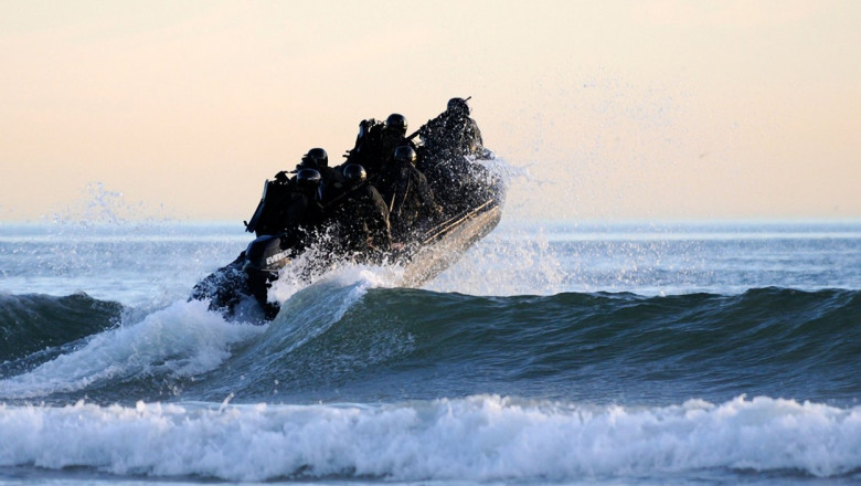 US Navy SEAL team members navigate the surf off the cost of Coronado during a maritime operations training exercise.