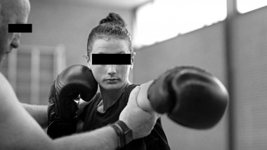 Teenage female fighter girl and trainer in a public gym