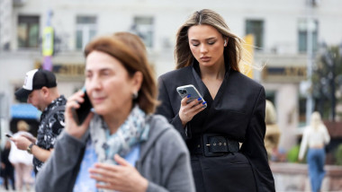 femei cu smartphone pe stradă