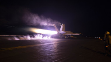 Avion american Super Hornet F/A-18 decolează de pe portavionul american USS Eisenhower în timpul nopții
