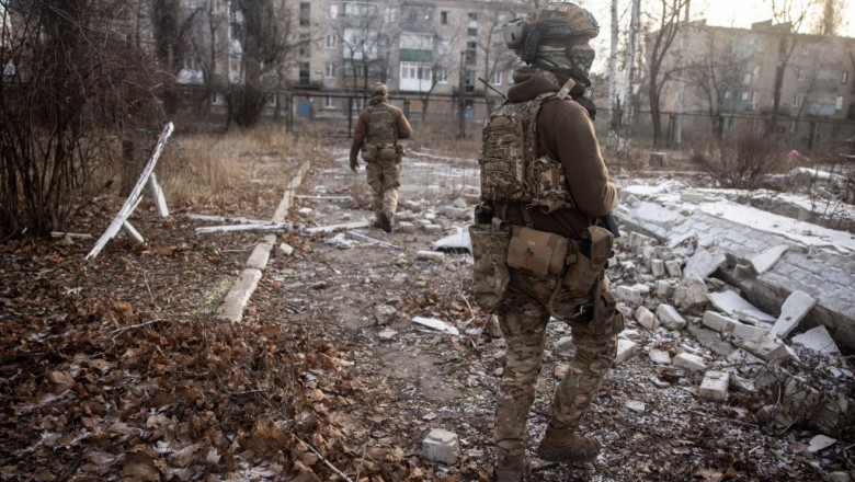 Militari ucraineni merg printre ruine la Avdiivka.