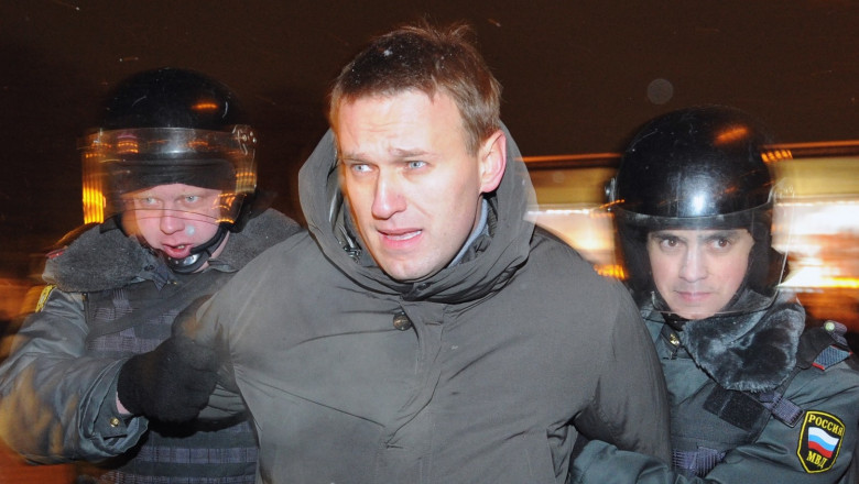 Navalnîi ținut de mâini de doi polițiști