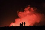 oameni care privesc o eruptie vulcanica in islanda