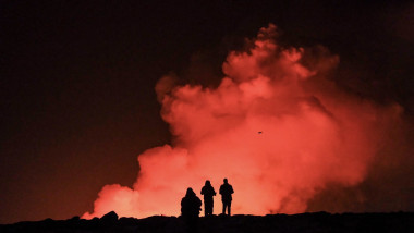 oameni care privesc o eruptie vulcanica in islanda