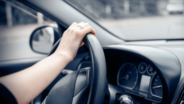 Woman driving his car. Hands holding the wheel.