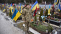 Military cadets stand near the graves of Ukrainian soldiers killed in the Russian-Ukrainian war and buried at the Lychakiv cemetery in Lviv