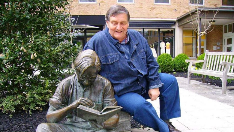 Alex Ștefănescu langa o statuie de om care citeste