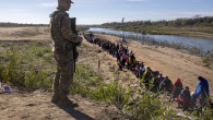 Un militar din Garda Națională a Texasului supraveghează peste 1.000 de migranți care au traversat ilegal fluviul Rio Grande din Mexic în SUA.