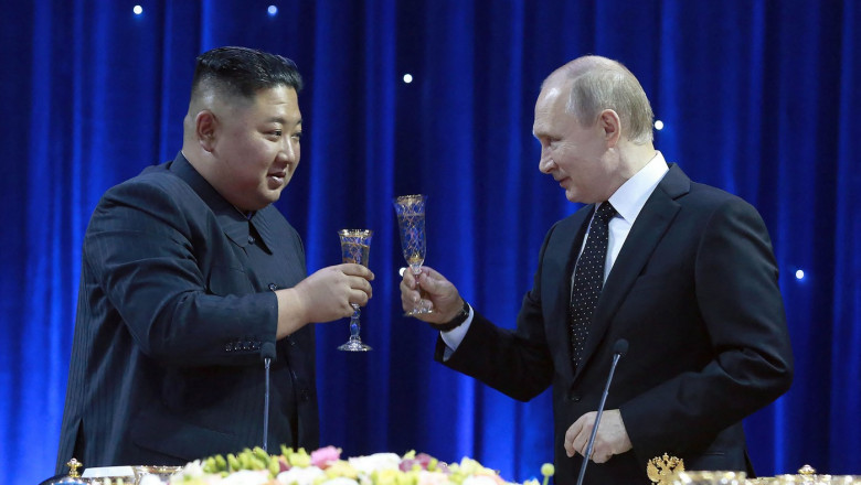 vladimir putin si kim jong un cu pahare de sampanie in mana