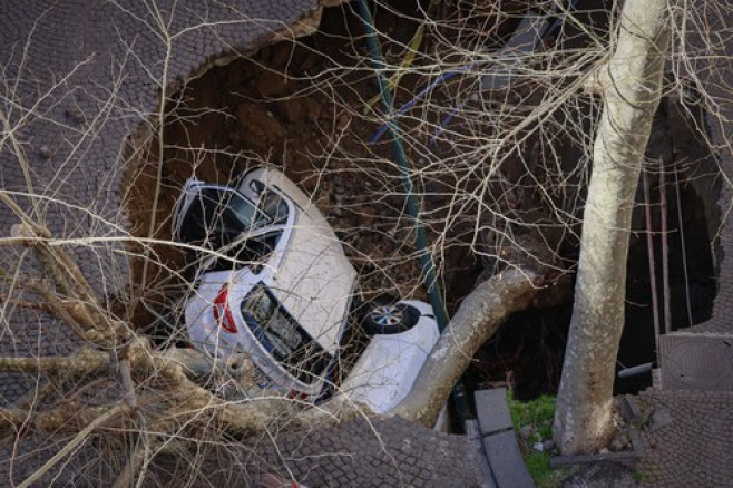 Italy, Naples: Cars swallowed by a huge sinkhole that opened up in a road in Naples's Vomero district