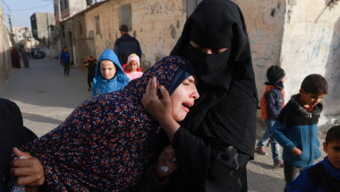 Rania Abu Anza plange in bratele unei femei dupa ce bebelusii i-au murit intr-un atac israelian