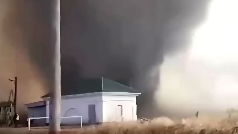 tornadă de foc lovește o casă albă cu acoperiș gri