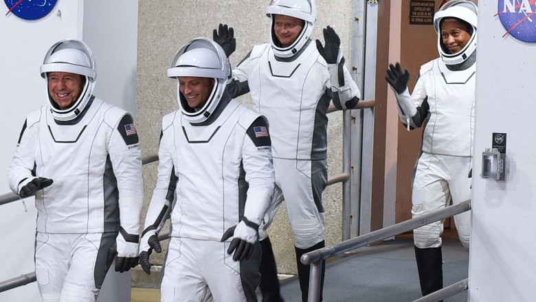 Astronauții unei echipe ruso-americane coboară pe rampă pregătiți să urce într-o navă spațială