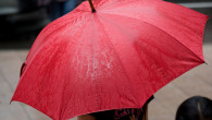 femeie cu umbrela rosie in ploaie