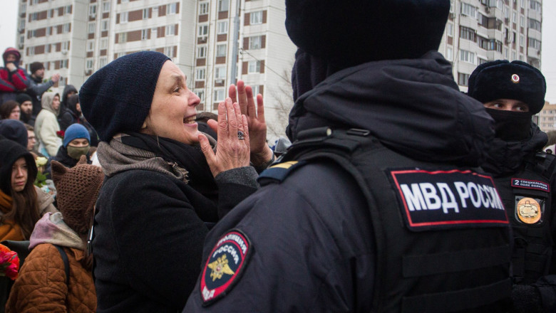 polițist și o femeie care plânge la înmormântarea lui navalnîi