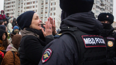 polițist și o femeie care plânge la înmormântarea lui navalnîi