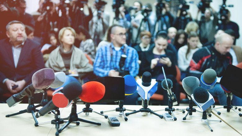jurnalisti la o conferinta, cu microfoanele in prim plan