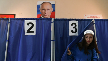 femeie iese din cabina de vot, tablou cu putin deasupra