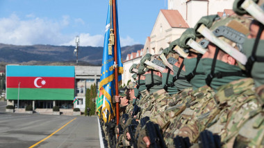 Soldați azeri în linie la o paradă militară, cu steagul azer pe fundal
