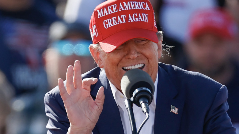 Trump cu șapcă roșie MAGA gesticulează