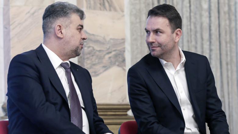 Marcel Ciolacu și Cătălin Drulă se uită unul la altul în timp ce stau pe scaune