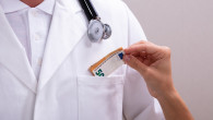 Female Hand Putting Money In Doctor's Pocket