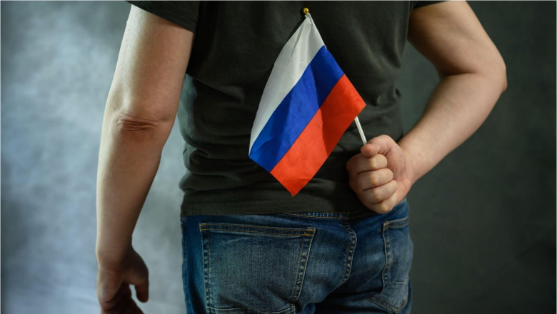 bărbat ascunde un steag al Rusiei la spate