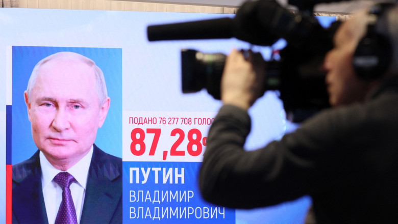 Vladimir Putin pe ecran cu scor cu un cameraman