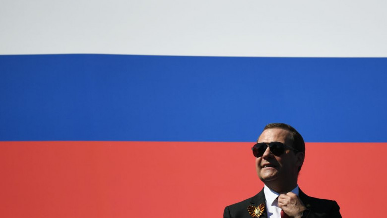 barbat cu ochelari de soare in fata drapelului rus