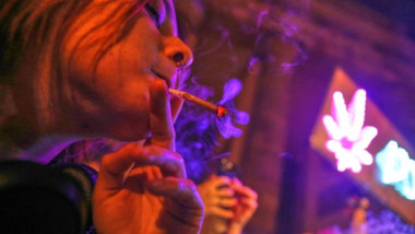 femeie fumeaza un joint de canabis