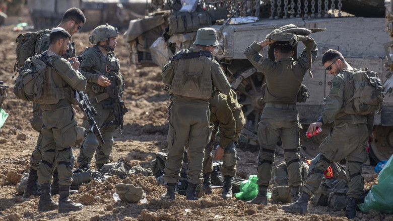 Israeli army soldiers prepare to leave a staging area inside Israel near the border with the Gaza Strip