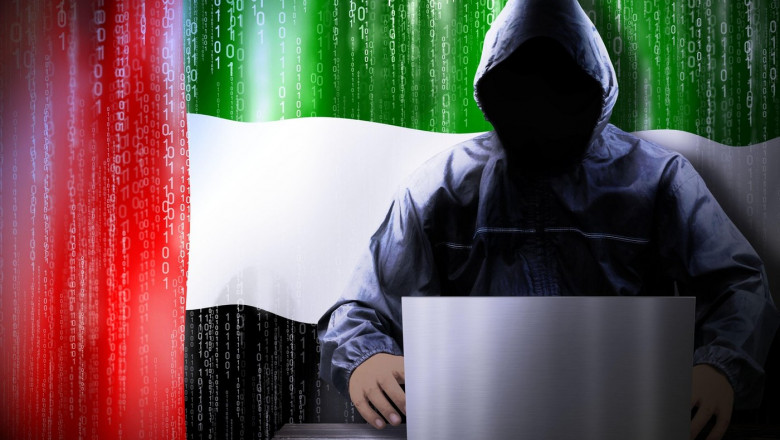 Anonymous hooded hacker, flag of United Arab Emirates, binary code - cyber attack concept